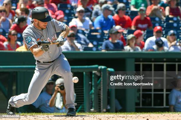 Miami Marlins starting pitcher Trevor Richards hits a sacrifice bunt to advance the runners during the game between the Miami Marlins and the...