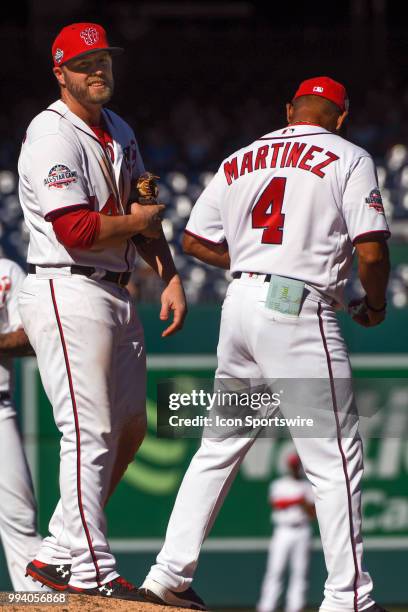 Washington Nationals manager Dave Martinez hands the ball to third baseman Mark Reynolds to pitch in the ninth inning during the game between the...