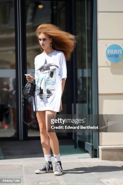 Model wears an oversized t-shirt with a printed shark, white socks, sneakers shoes , outside Jean-Paul Gaultier, during Paris Fashion Week Haute...