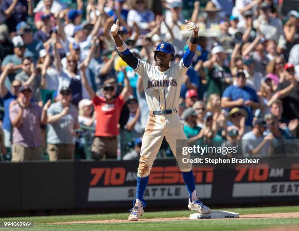 Dee Gordon of the Seattle Mariners reacts after hitting double off relief pitcher Jake McGee of the Colorado Rockies and advancing to first base on a...