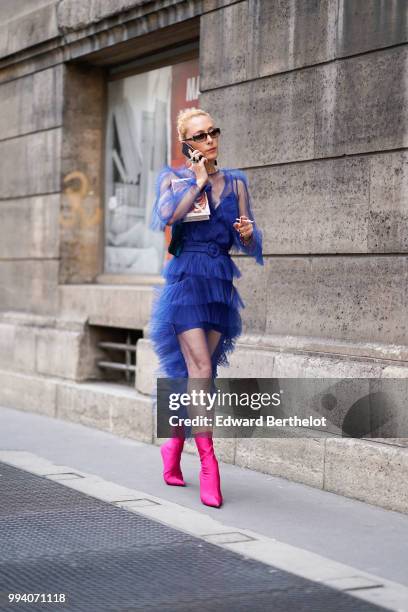 Elina Halimi wears a blue ruffled lace mesh dress, sunglasses, pink boots , outside Elie Saab, during Paris Fashion Week Haute Couture Fall Winter...