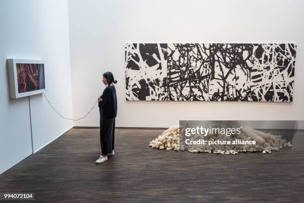 Visitor stands next to an installation of the artist Mohammed Al Qassab at the exhibition "Portrait of a Nation" at the "me Collectors Room" in...