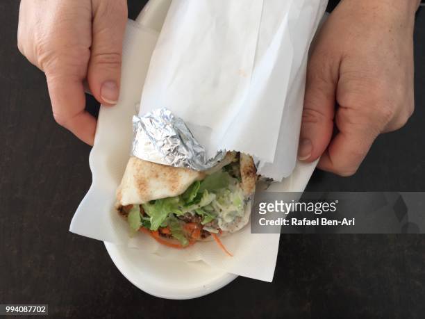 woman serving lebanese falafel wrap - rafael ben ari fotografías e imágenes de stock