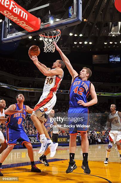 Stephen Curry of the Golden State Warriors shoots a layup against Danilo Gallinari and David Lee of the New York Knicks during the game at Oracle...