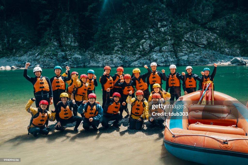 Large group of men and women preparing to go white water river rafting