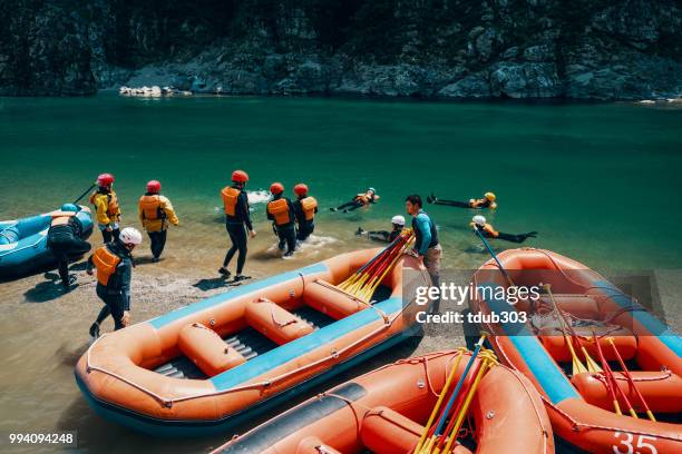 Group of men and women preparing to go white water river rafting