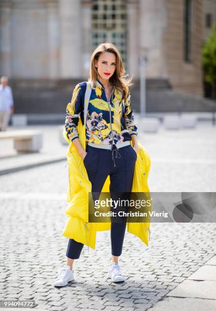 Alexandra Lapp is seen wearing a blouson jacket with floral print, blue drawstring pants and a bright yellow duffle coat with a yellow fur hood from...