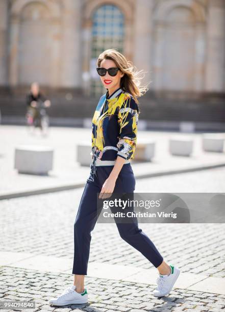 Alexandra Lapp is seen wearing a blouson jacket with floral print, blue drawstring pants and a bright yellow duffle coat with a yellow fur hood from...