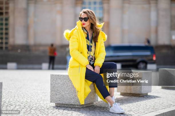 Alexandra Lapp is seen wearing a blouson jacket with floral print, blue drawstring pants and a bright yellow duffle coat with a yellow fur hood from...