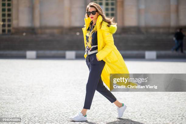 Alexandra Lapp is seen wearing a blouson jacket with floral print, blue drawstring pants and a bright yellow duffle coat with a yellow fur hood from...