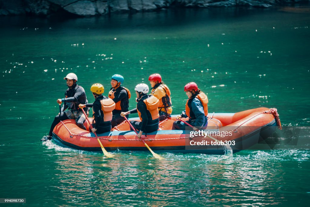 Gruppe von Männern und Frauen in einem Floß auf einem Fluss