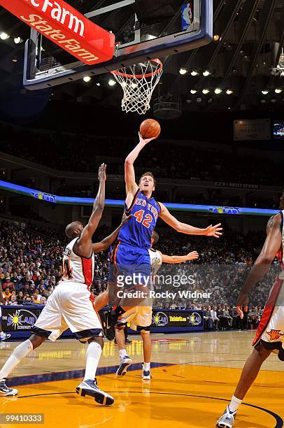 David Lee of the New York Knicks goes up for a shot against Anthony Tolliver and Stephen Curry of the Golden State Warriors during the game at Oracle...