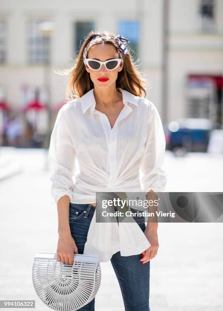 Alexandra Lapp wearing La Chemise Olhao in off white by Jacquemus, blue AG Adriano Goldschmied denim, white Inez leather sandals by Saint Laurent,...