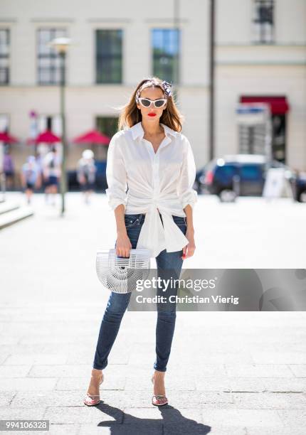 Alexandra Lapp wearing La Chemise Olhao in off white by Jacquemus, blue AG Adriano Goldschmied denim, white Inez leather sandals by Saint Laurent,...