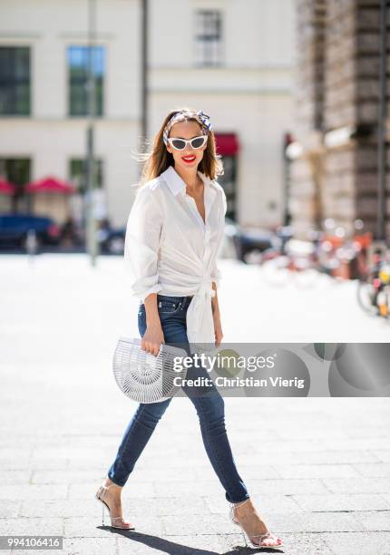 Alexandra Lapp wearing La Chemise Olhao in off white by Jacquemus, blue AG Adriano Goldschmied denim, white Inez leather sandals by Saint Laurent,...