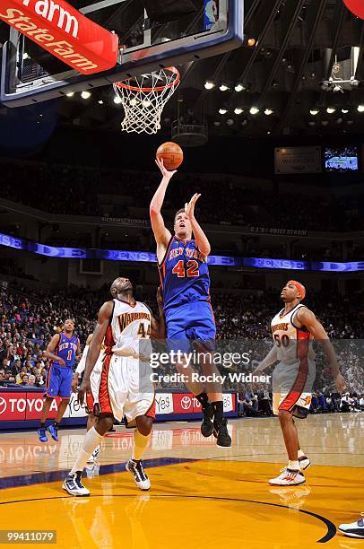 David Lee of the New York Knicks goes up for a shot against Anthony Tolliver and Corey Maggette of the Golden State Warriors during the game at...