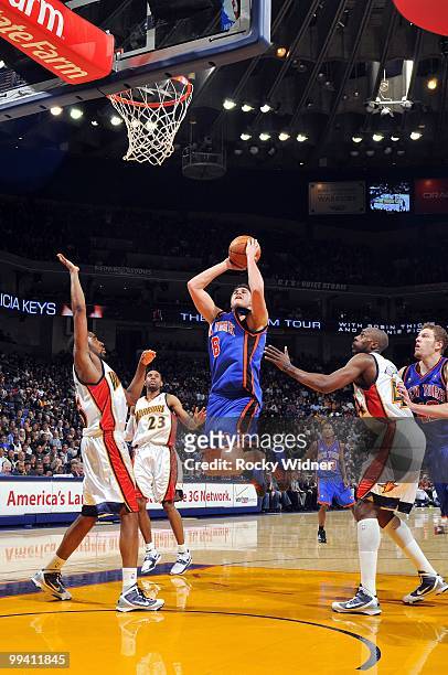 Danilo Gallinari of the New York Knicks goes up for a shot against Reggie Williams and Anthony Tolliver of the Golden State Warriors during the game...