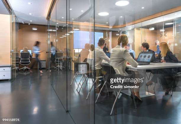 business people having meeting in conference room - older women in short skirts stock pictures, royalty-free photos & images