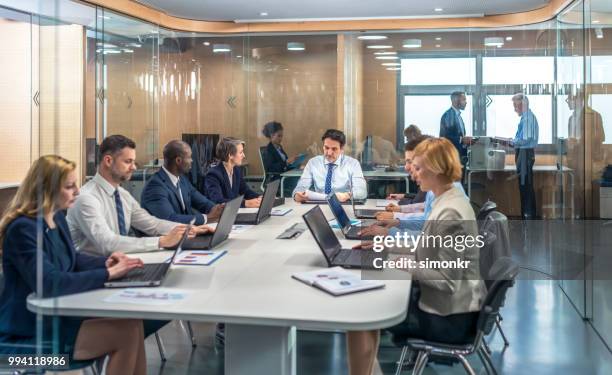 business people having meeting in conference room - older women in short skirts stock pictures, royalty-free photos & images