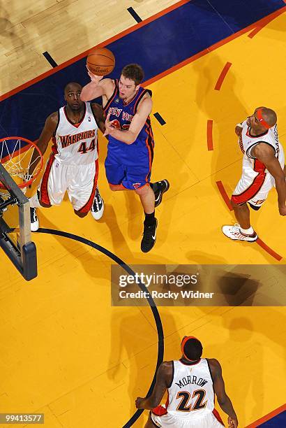 David Lee of the New York Knicks goes up for a shot against Anthony Tolliver, Anthony Morrow and Corey Maggette of the Golden State Warriors during...