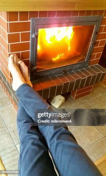 personal perspective of men's legs against fireplace in house - mikroman6 imagens e fotografias de stock