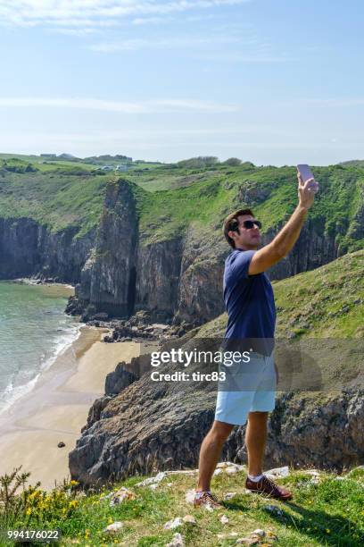 single brazilian man lifestyle portrait at beach headland - dyfed stock pictures, royalty-free photos & images