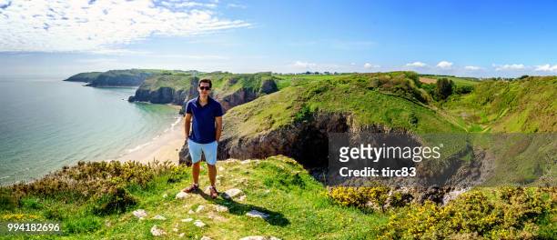 single brazilian man lifestyle portrait at beach headland - dyfed stock pictures, royalty-free photos & images