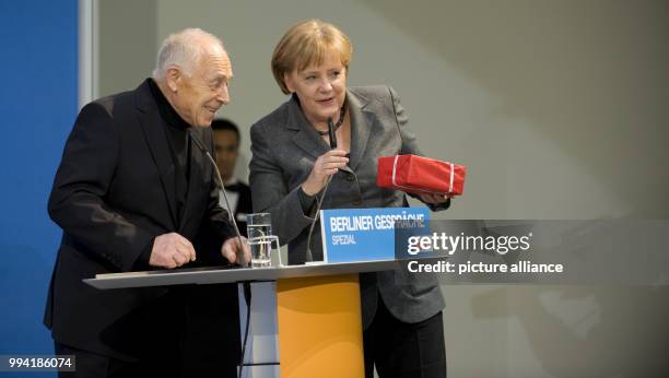 The former Secretary General of the Christian Democratic Party of Germany , Heiner Geissler, receives a birthday present from the German Chancellor...
