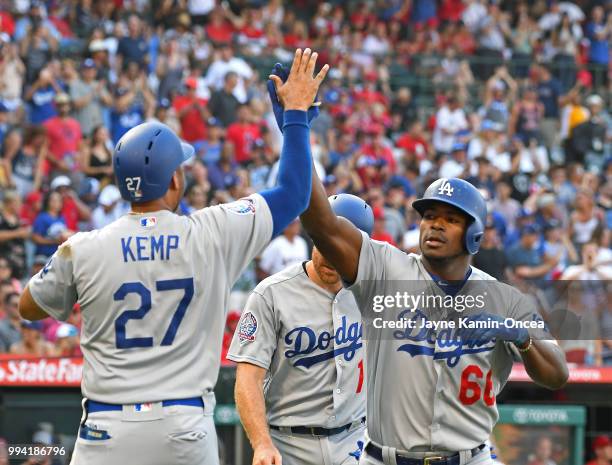 Yasiel Puig of the Los Angeles Dodgers is greeted by Matt Kemp and Logan Forsythe after hitting a three-run home run in the second inning against the...