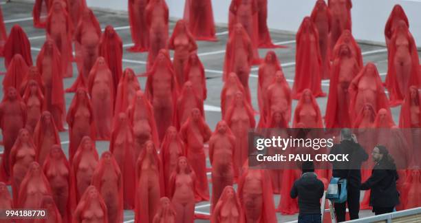 Over 200 people pose partially naked on a shopping centre rooftop car park as part of the latest project by US photographer Spencer Tunick in...