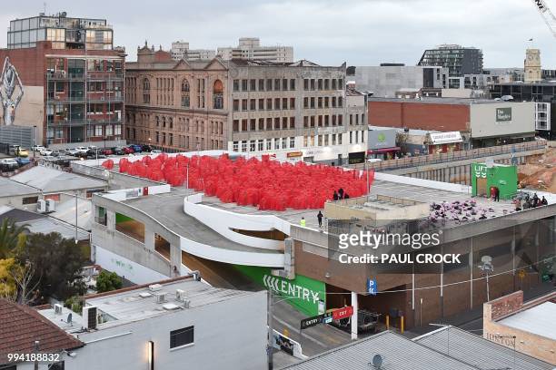 Over 200 people pose partially naked on a shopping centre rooftop car park as part of US photographer Spencer Tunicks latest artwork in Melbourne on...