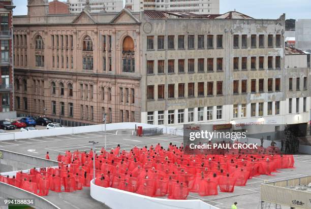 Over 200 people pose partially naked on a shopping centre rooftop car park as part of the latest project by US photographer Spencer Tunick in...