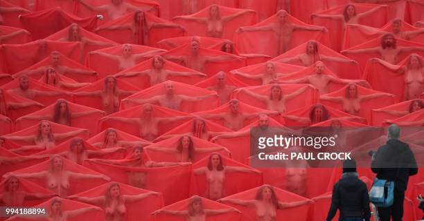 Over 200 people pose partially naked on a shopping centre rooftop car park as part of the latest project by US photographer Spencer Tunick in...