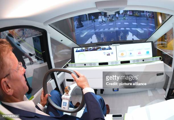Hannes Roth sits in a technology carrier for the driving of the future at the stand of Harman, an exhibitor at the 'New Mobility World' at the...