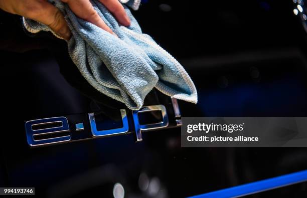 Woman cleans the rear-view window of a Volkswagen 'e-Up!' at the stand of VW at the International Automobile Fair in Frankfurt/Main, Germany, 12...