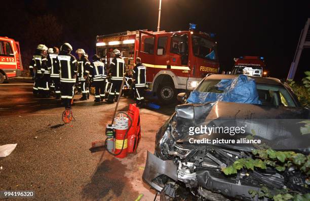 Firefighters pack in their equipment next to a destroyed car on motorway A2 near Oelde, Germany, 12 September 2017. During a collision on the...