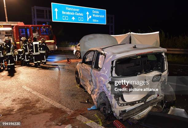 Firefighters pack in their equipment next to a destroyed car on motorway A2 near Oelde, Germany, 12 September 2017. During a collision on the...