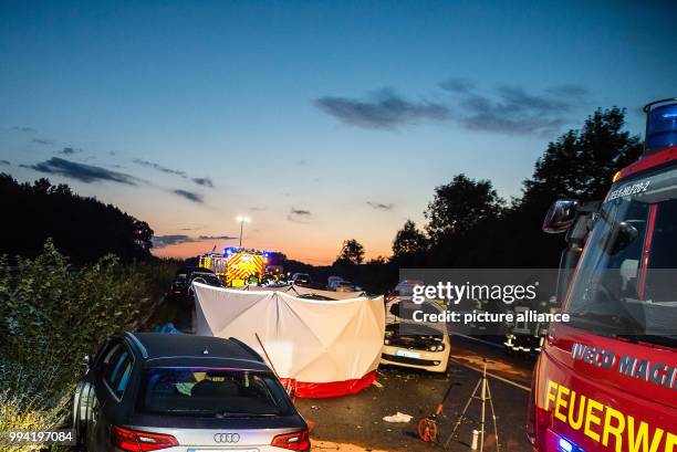 Firefighters stand next to a destroyed car on motorway A2 near Oelde, Germany, 12 September 2017. During a collision on the Autobahn 2 in the...