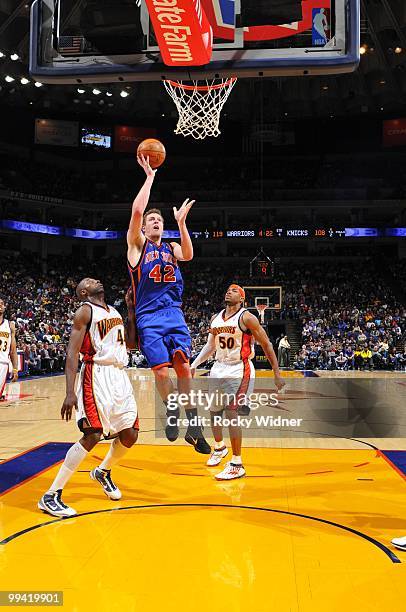 David Lee of the New York Knicks goes up for a shot against Anthony Tolliver and Corey Maggette of the Golden State Warriors during the game at...