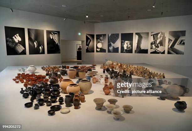 Roman clay jugs are positioned on a platform in front of photographs by Anna and Bernhard Blume at the Kolumba Museum in Cologne, Germany, 13...