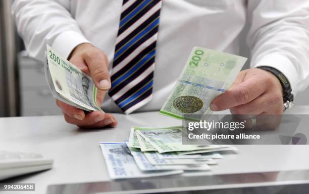 An employsee counts Danish Krone at an exchange office in Munich, Germany, 13 September 2017. President of the European Commission Juncker wants to...