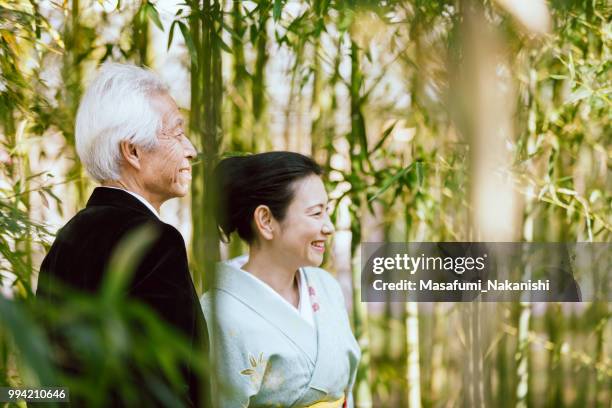 asian couple of gray hair senior and kimono woman who are walking in bamboo grove - masafumi nakanishi imagens e fotografias de stock