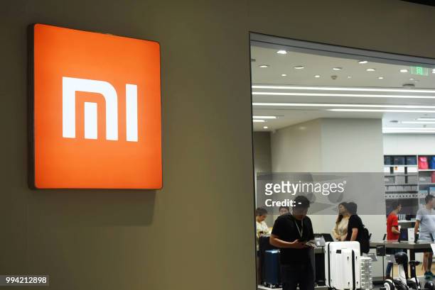 Customers look at products at a Xiaomi store in Hangzhou in China's eastern Zhejiang province on July 9, 2018. - Chinese smartphone giant Xiaomi...