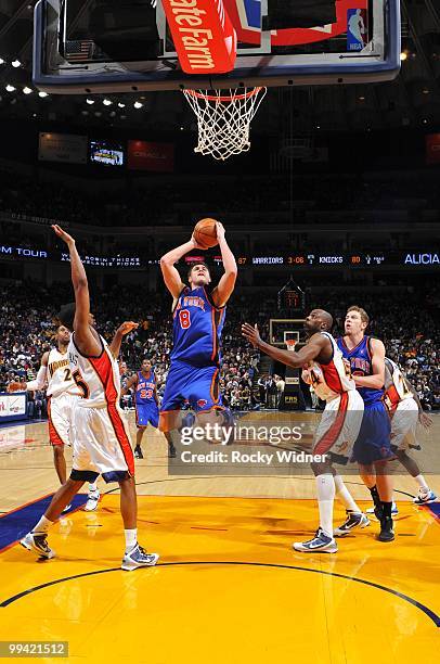 Danilo Gallinari of the New York Knicks goes up for a shot against Reggie Williams and Anthony Tolliver of the Golden State Warriors during the game...