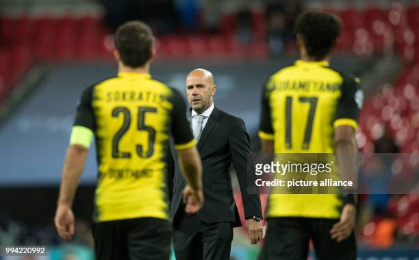 Dpatop - Dortmund's manager Peter Bosz walks towards his players Sokratis and Pierre-Emerick Aubameyang at the end of the Champions League group...