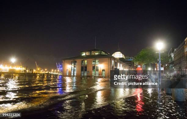 Cyclist rides past the flooded fish market in the harbour in Hamburg, Germany, 13 September 2017. Storms along the German North Sea coast, the first...