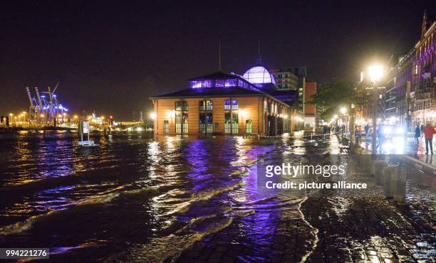 Pedestrians and cars make their way past the flooded fish market in the harbour in Hamburg, Germany, 13 September 2017. Storms along the German North...