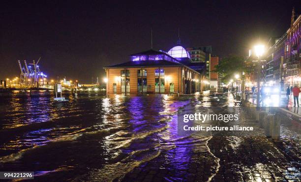 Dpatop - Pedestrians and cars make their way past the flooded fish market in the harbour in Hamburg, Germany, 13 September 2017. Storms along the...