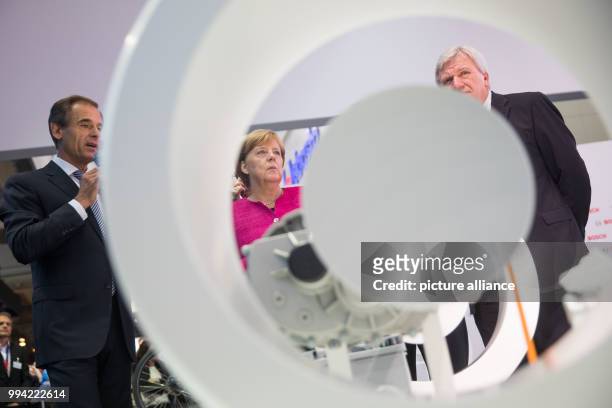 German chancellor Angela Merkel looks at an electric engine system at the Bosch display with Bosch CEO Volkmar Denner the premier of Hesse Volker...