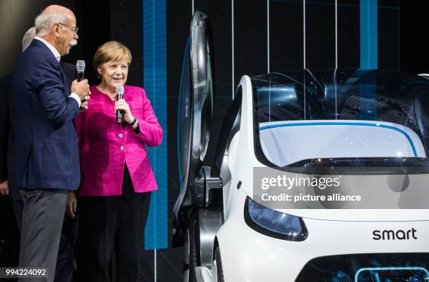 German chancellor Angela Merkel with Daimler CEO Dieter Zetsche in front of a Mercedes EQ A concept e-car at the opening of the International...
